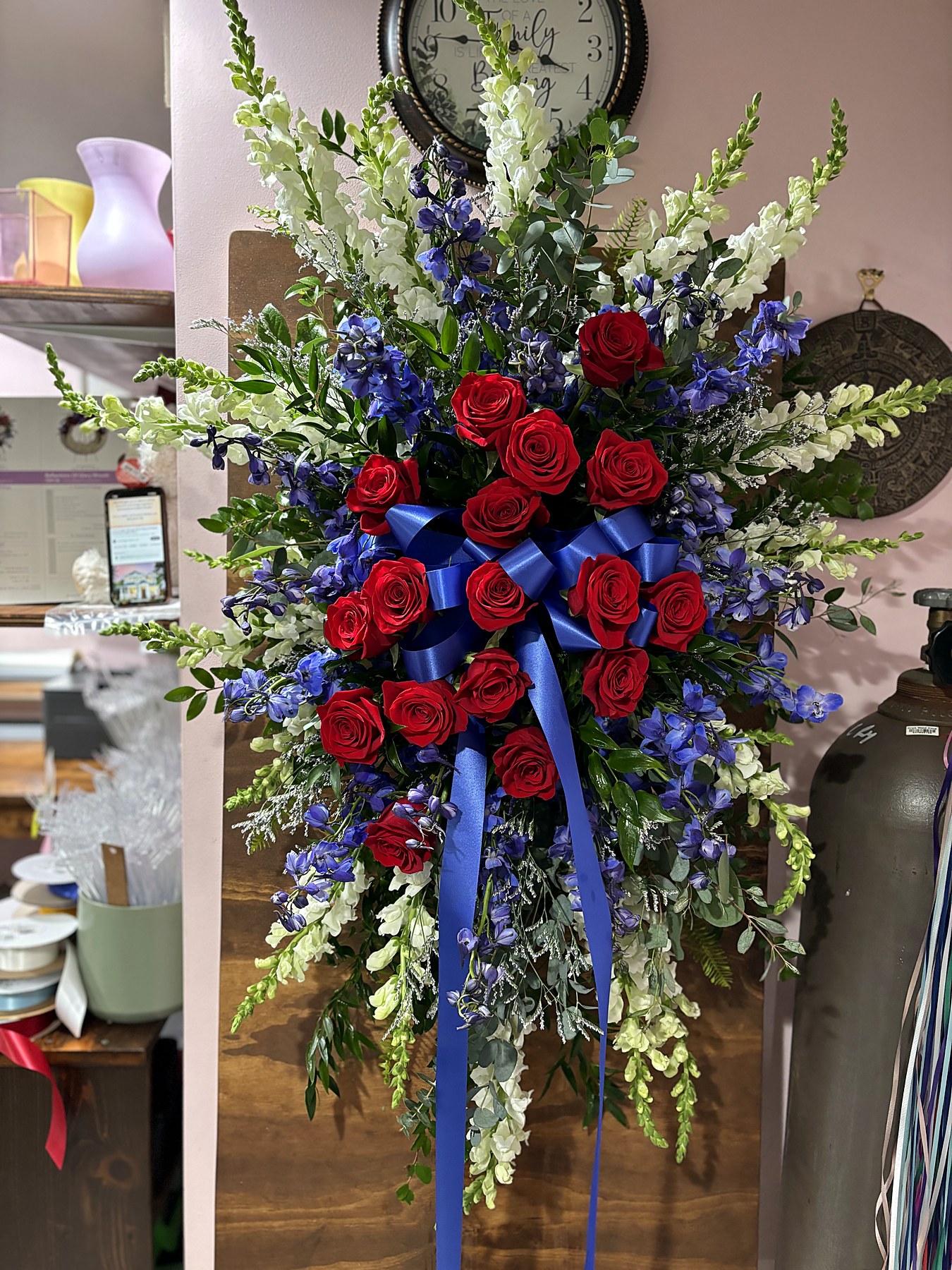 Standing spray of red, white, and blue roses with a patriotic ribbon