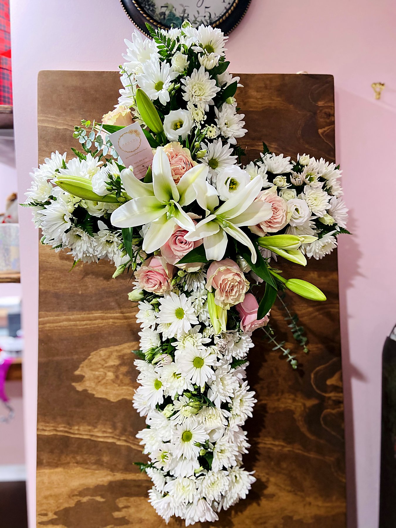 Cross-shaped tribute of white chrysanthemums and daisies with pink roses and lilies