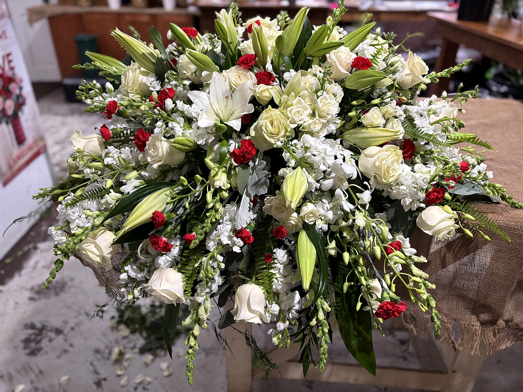 Round sympathy arrangement of white and red roses, alternate view