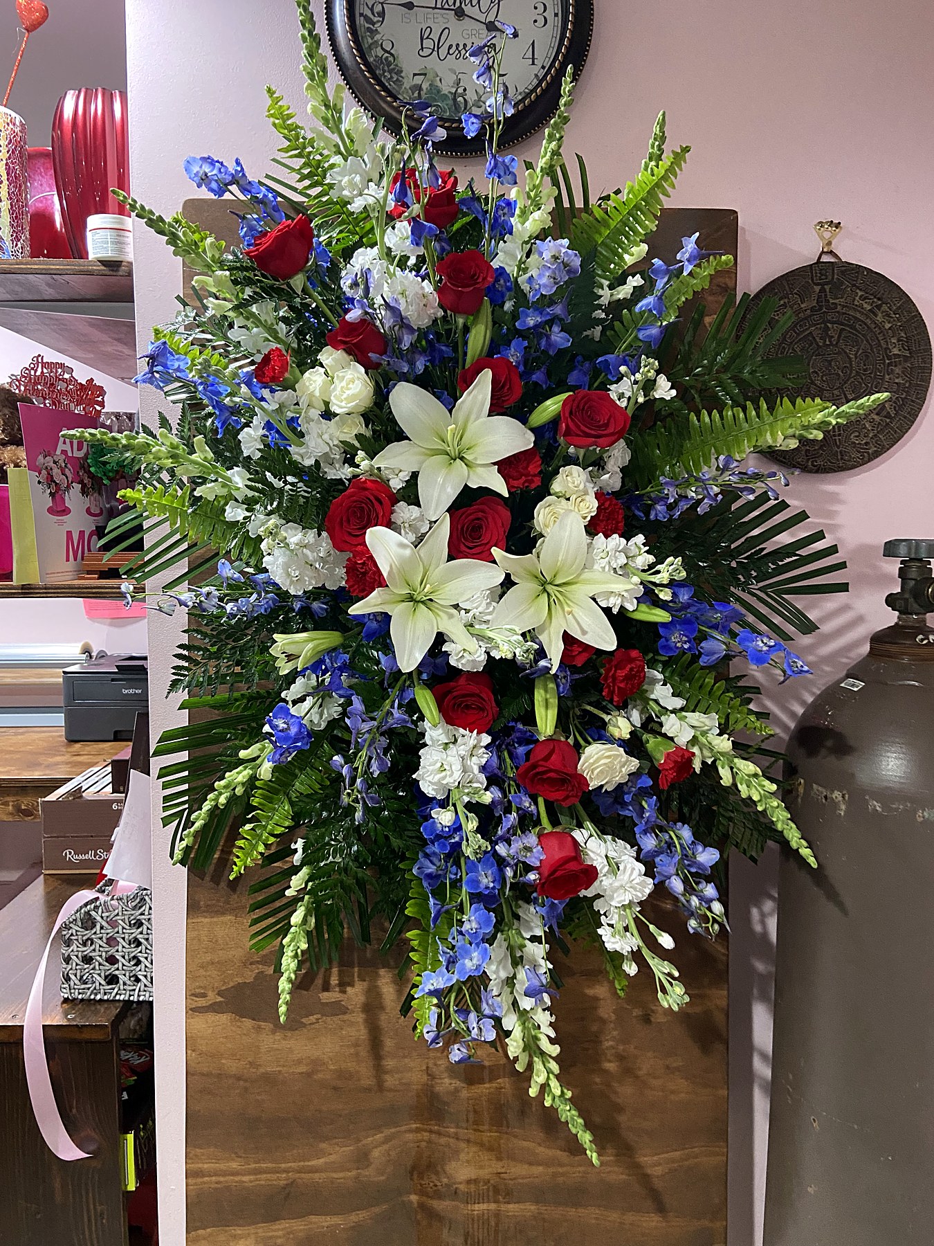 Standing spray of red, white, and blue roses with lilies