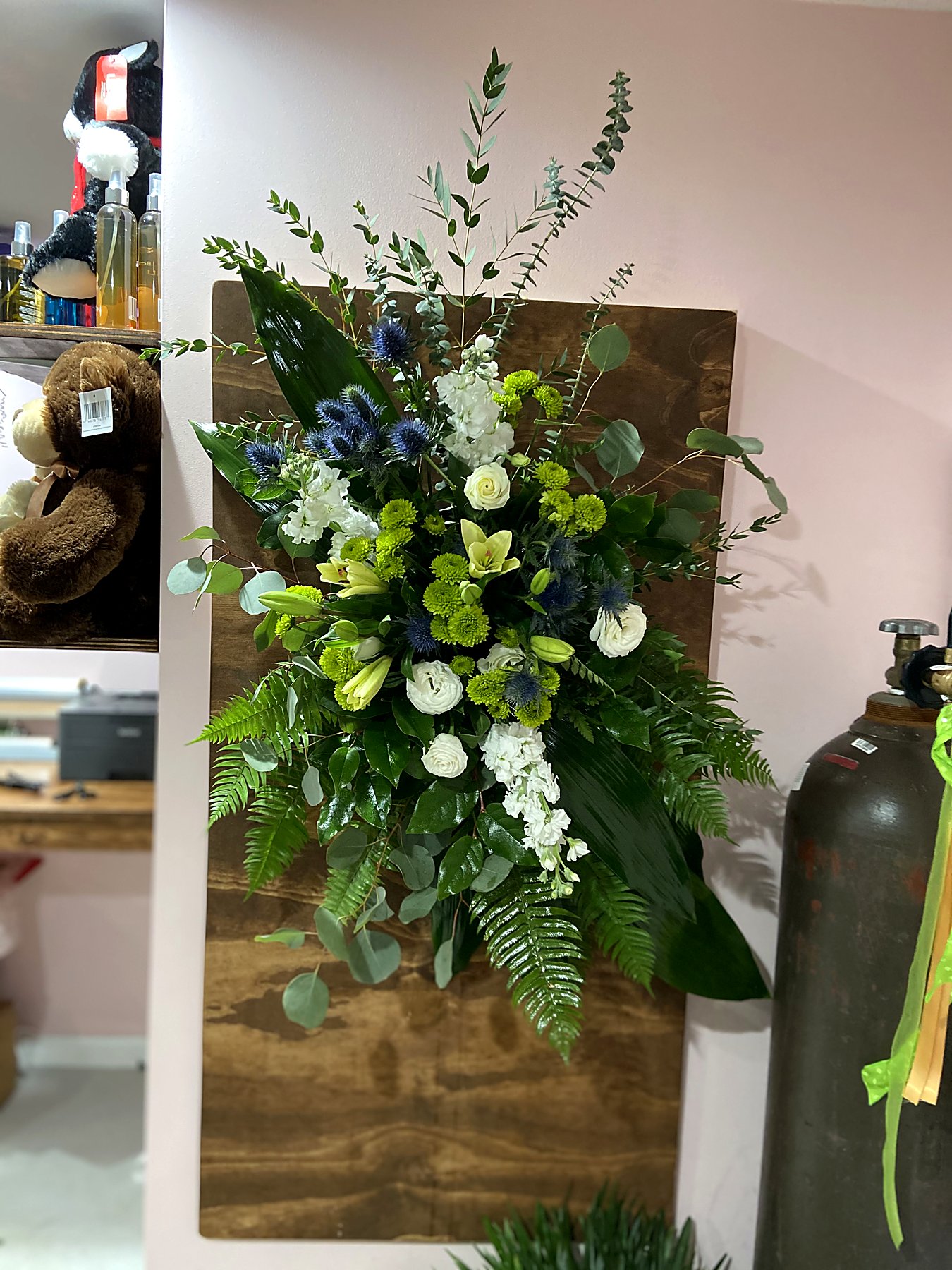 Standing spray of white stock and roses with green chrysanthemums and blue thistle