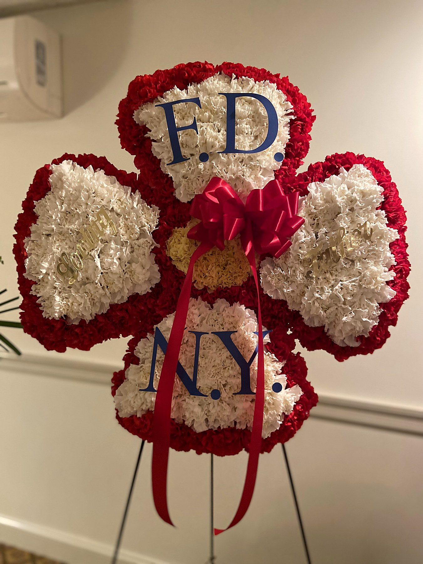 Four-leaf clover tribute of white and red carnations spelling F.D.N.Y.